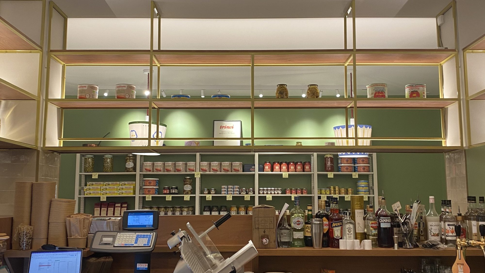 The counter of Toscanacci fine Italian deli in Pantin, with its meat slicer and shelves of Italian products
