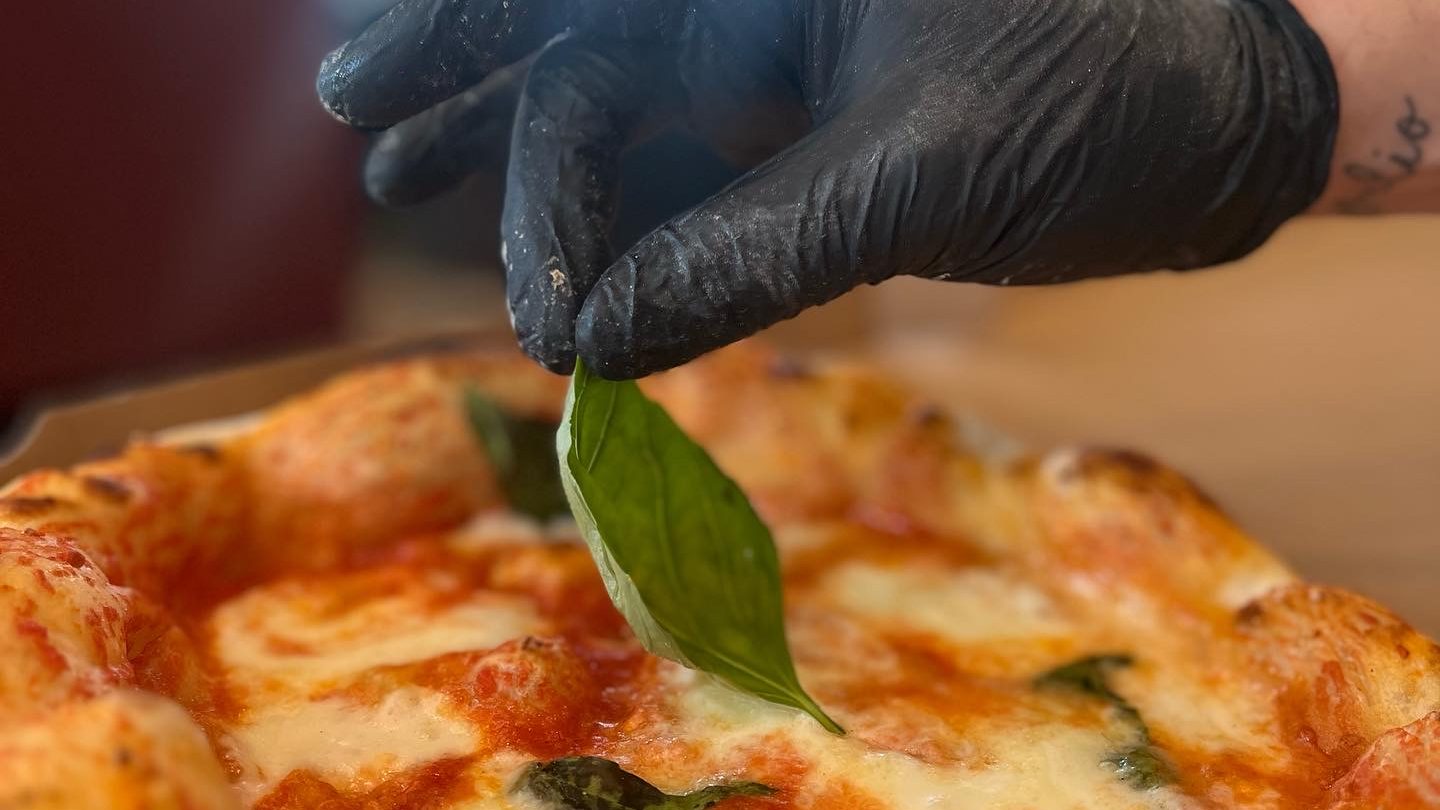 Long-fermented margherita pizza topped with a fresh basil leaf by hand, at Toscanacci pizzeria in Pantin