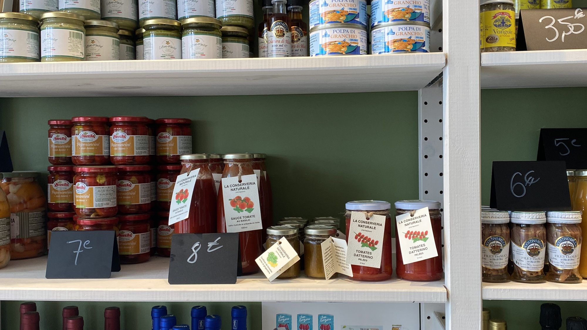 Tomato sauces, preserves, pestos and Italian wines on the shelves of Toscanacci Italian deli in Pantin