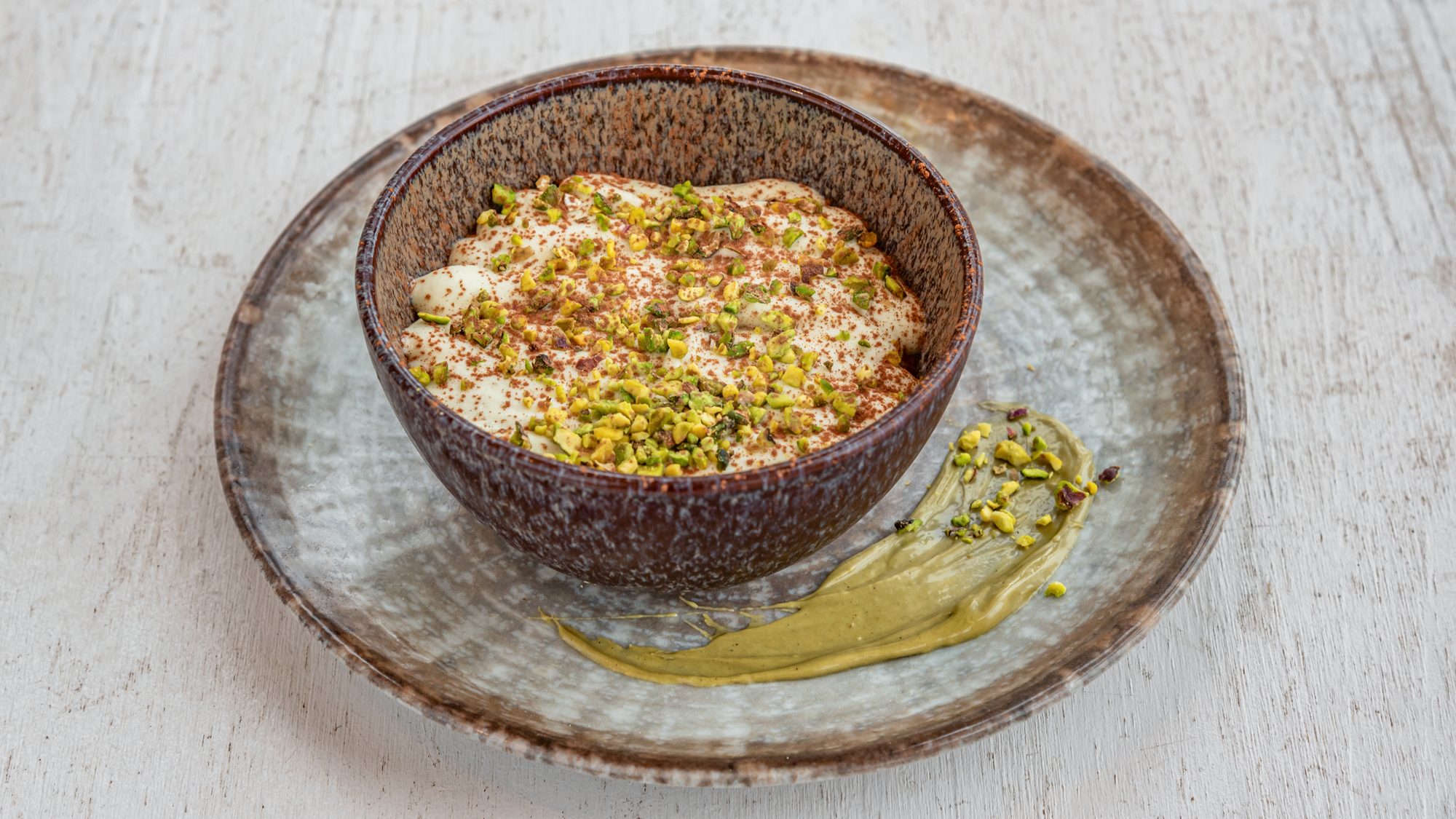 Homemade pistachio tiramisù with chopped pistachios and pistachio cream at Toscanacci, Pantin